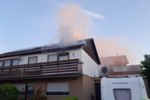 Ein mehrgeschossiges Einfamilienhaus, zu dem es auf der Vorder- und Rückseite aus den geschlossenen Rolläden herausqualmt.